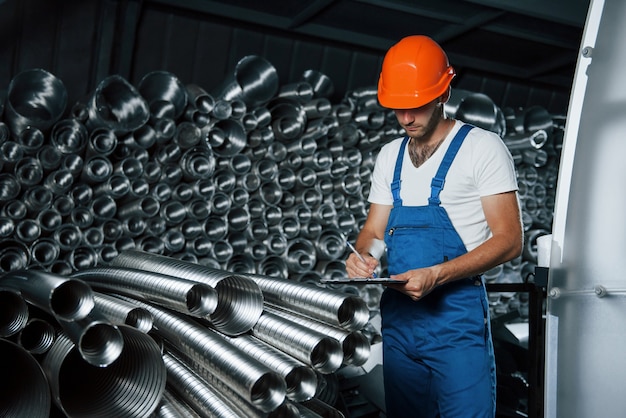 Foto l'uomo in uniforme lavora alla produzione