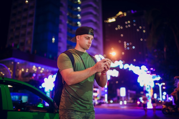 Man use of mobile phone in the city at night