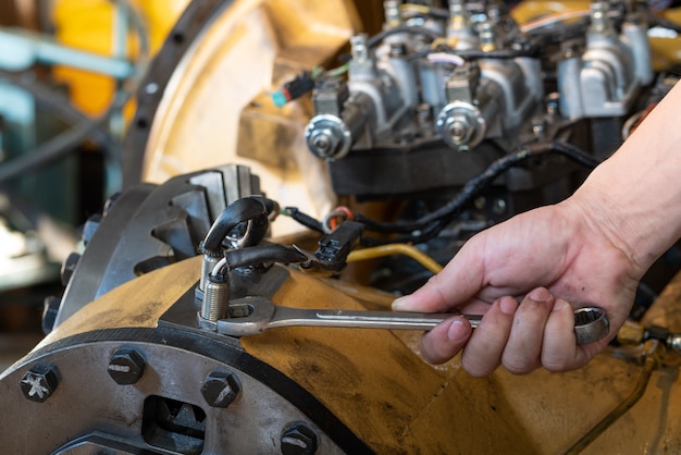 Man use a wrench tool to loosen lock nut of speed sensor on transmission