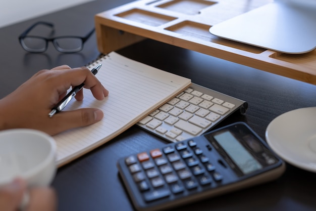 Man uses calculator to calculate costs in office 