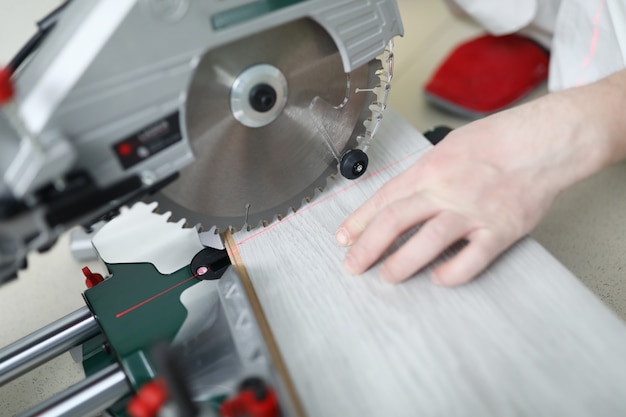 Man uses circular saw table while cutting laminate