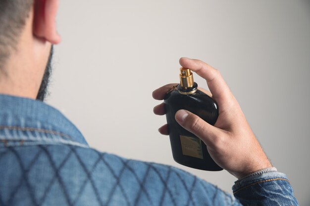 Man uses masculine perfume on himself