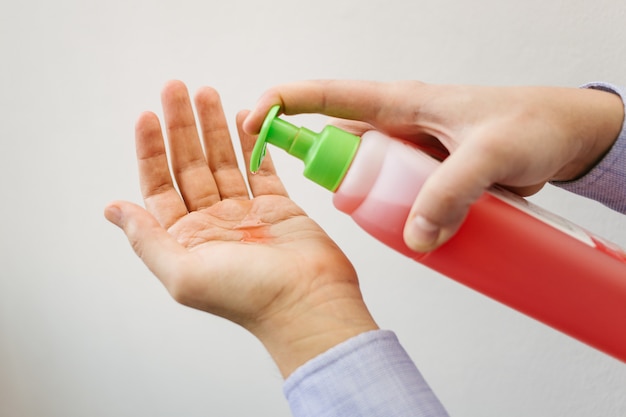 A man uses red antibacterial gel.