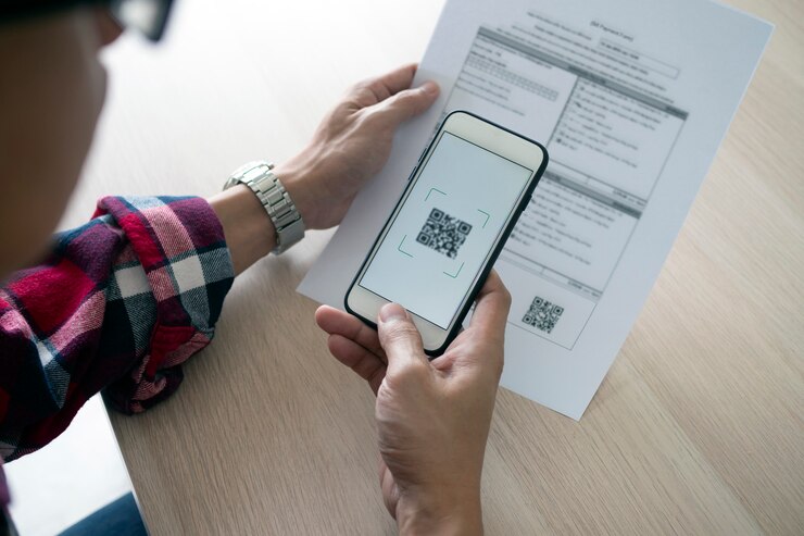 Man uses a smartphone to scan the QR code to pay monthly credit card bills