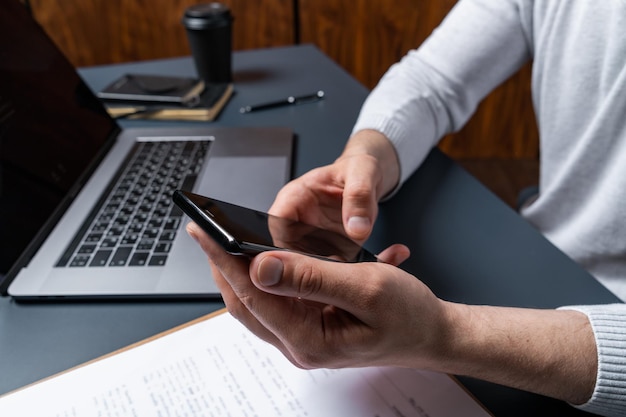 Man uses smartphone on work hours Concept of cellular addiction