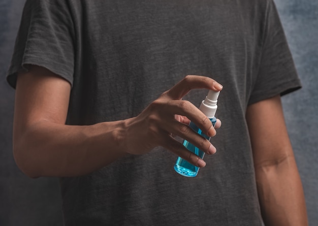 man using alcohol hand spray for cleaning