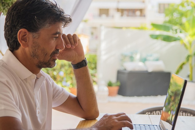 Man Using Blank Screen Laptop In Living Room. Teleworking