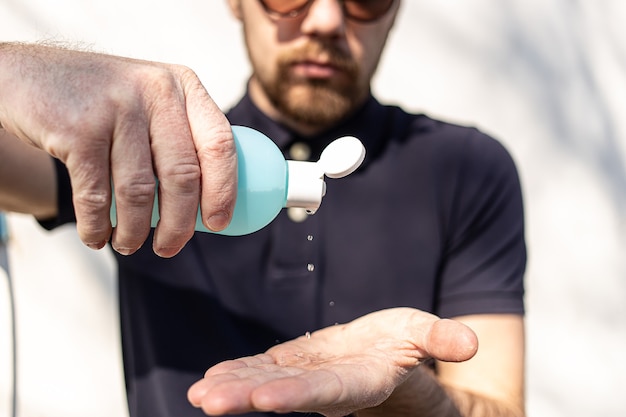 Man using bottle of antibacterial sanitizer