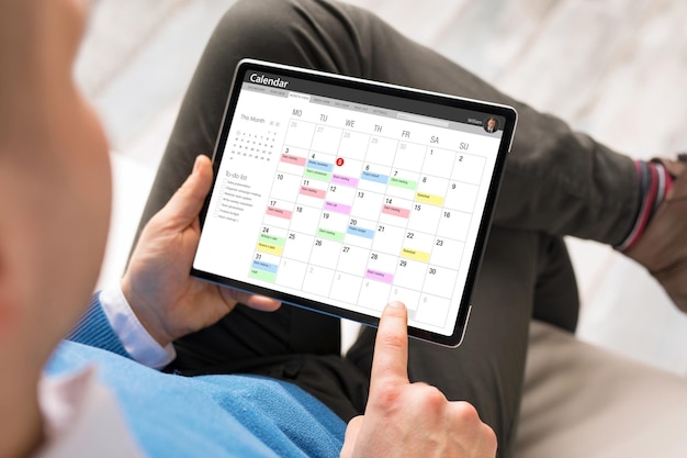 Foto uomo che utilizza l'app del calendario sul tablet