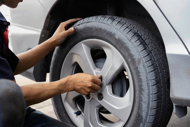 Man using car mechanic Block the wind wheel. To check your tires and brake for car.Auto mechanic Preparing For the work.