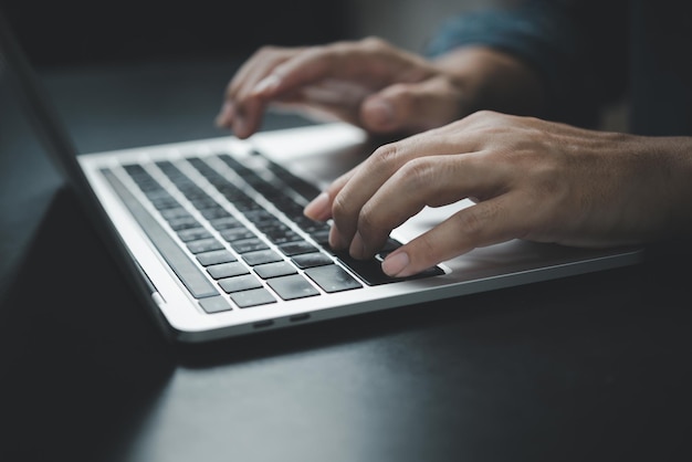 Man using computer laptop working internet searching social media and communications digital technology online at desk