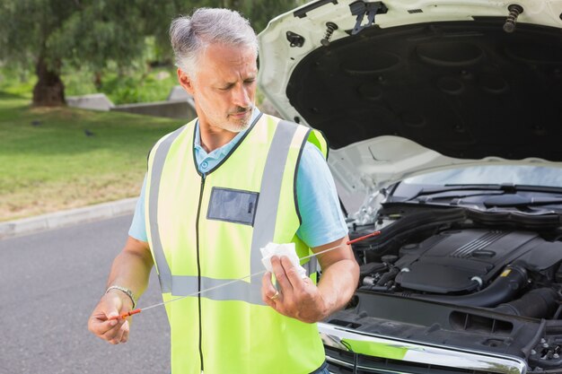 Man using dipstick to check oil 