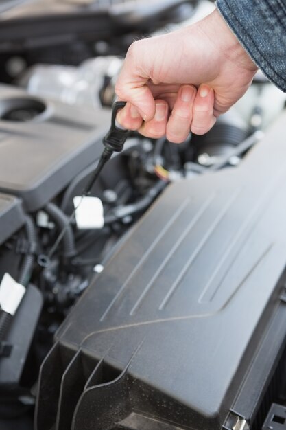 Man using dipstick to check oil