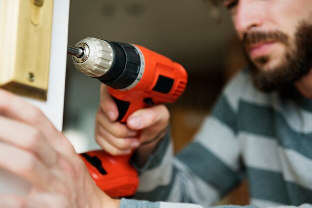 Man using electronic drill install door