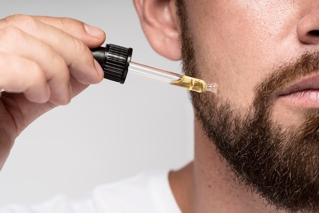 Photo man using face oils close-up