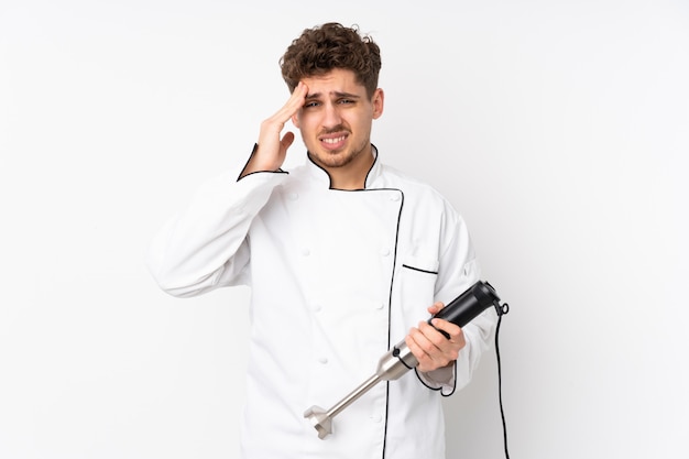 Man using hand blender on white wall unhappy and frustrated with something