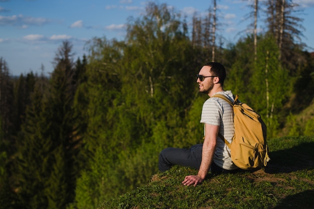 Man using hiking with backpack outdoors in woods