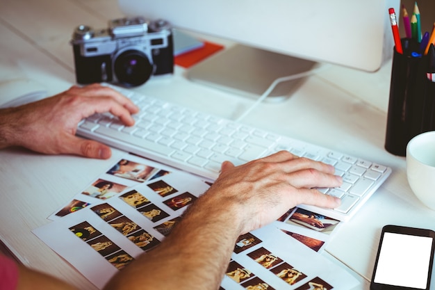 Foto uomo che usa il suo computer alla sua scrivania