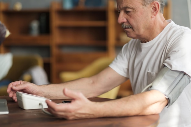 Man using home blood pressure machine to check his vital statistics