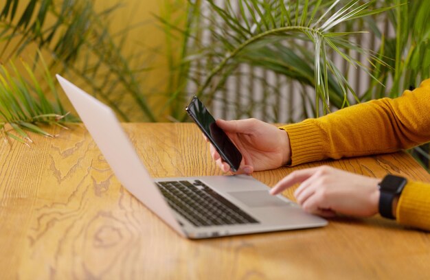 Photo man using iphone and macbook in office