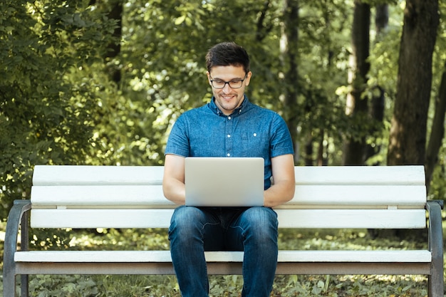 Man using laptop in city park