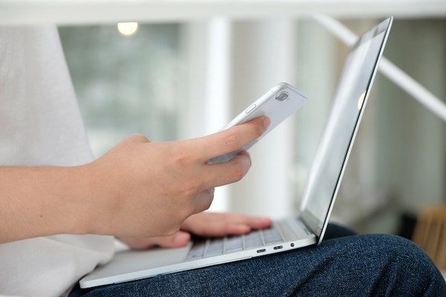 Man using laptop computer and smart phone