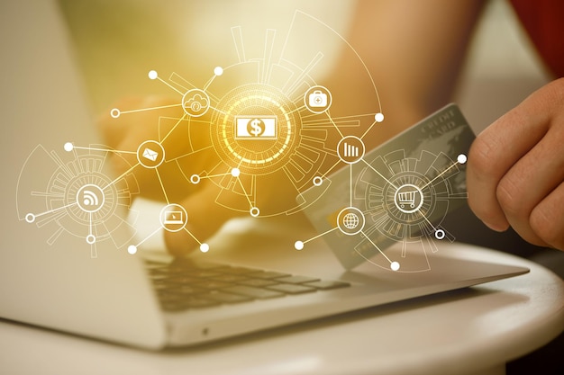 Man using laptop and credit card for online payment at table indoors closeup