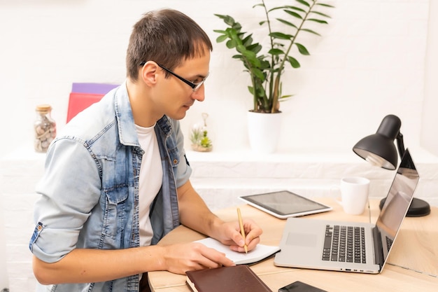 Man Using Laptop On Desk At Home