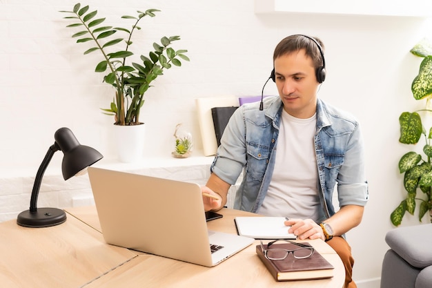 Man Using Laptop On Desk At Home