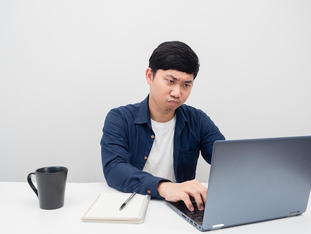 Man using laptop on the desk workplace serious working emotion