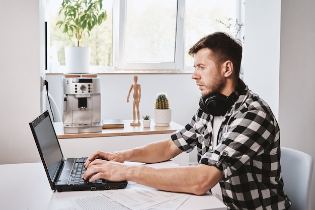 Photo man using laptop at home office