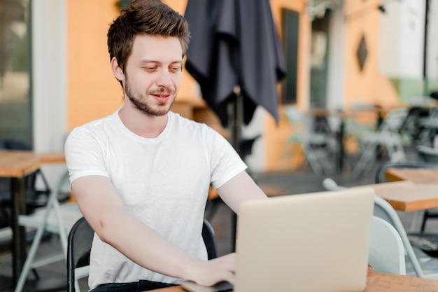 Man using laptop for remote work in cafe