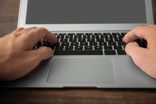 Man using laptop on table closeup