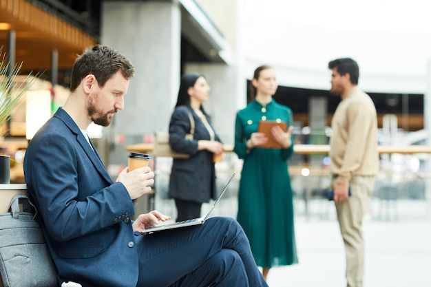 Photo man using laptop in waiting lounge