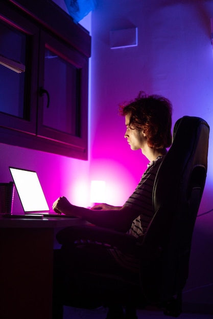 Photo man using laptop while sitting in darkroom