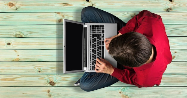 Man using laptop while sitting on floor