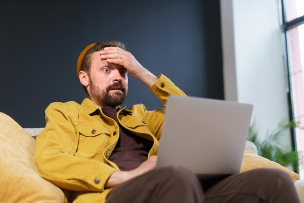 Man using laptop while sitting on sofa at home