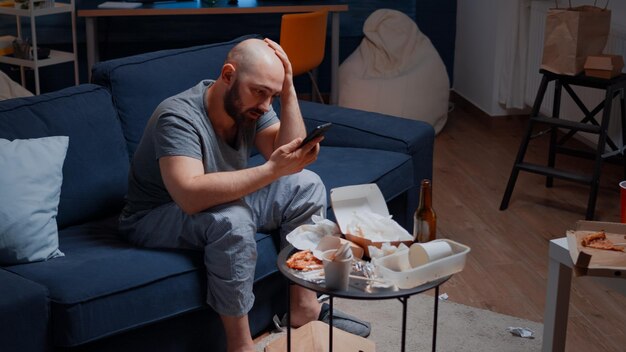 Photo man using laptop while sitting on sofa