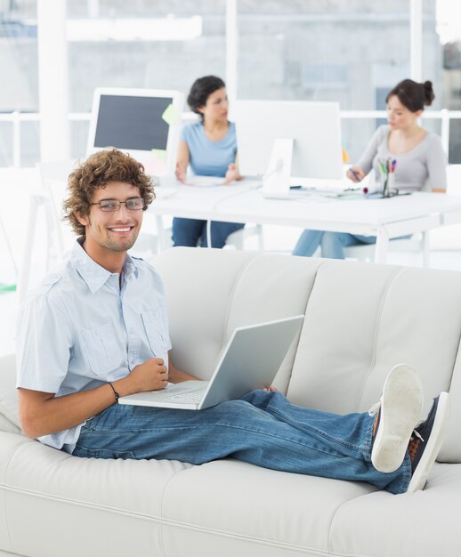 Man using laptop with colleagues at creative office