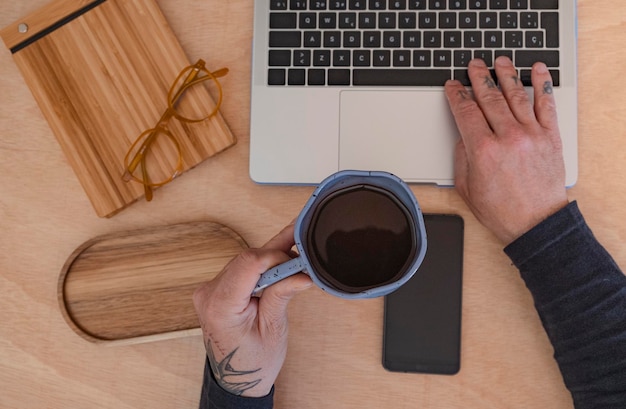 man using laptop with cup of coffee