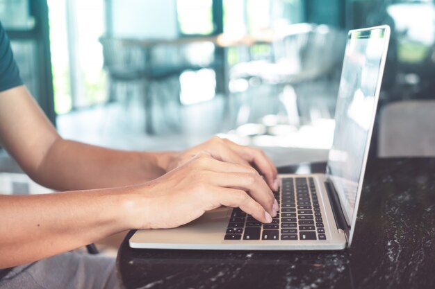 Man using laptop to work and study on working desk.