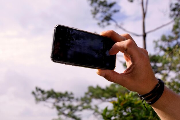 写真 空に向かって携帯電話を使っている男性