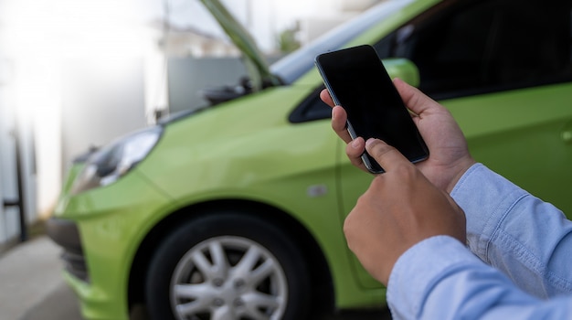 Uomo usando una telefonata per assistenza aiutare con un guasto alla panchina dell'auto