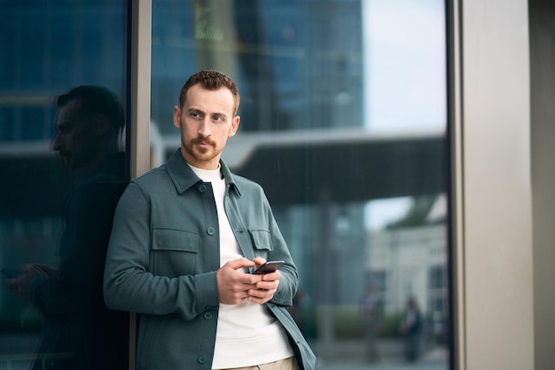 Man using mobile phone standing on the street, copy space