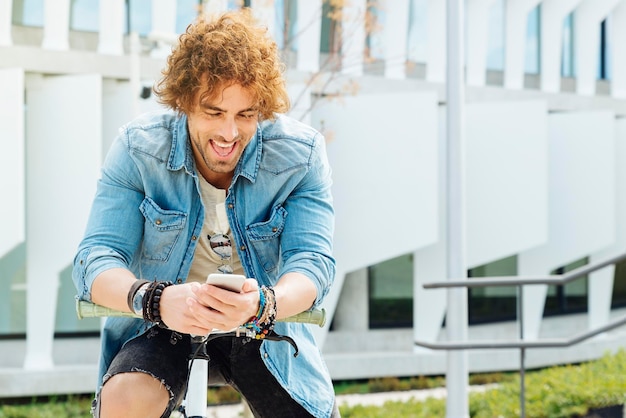 Photo man using mobile phone while sitting on bicycle