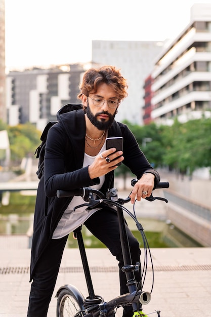 그의 자전거에 앉아있는 동안 휴대 전화를 사용하는 남자