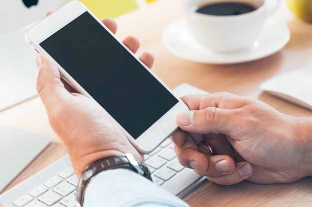 Man using mobile smart phone, Business man hands using cell phone at office desk,