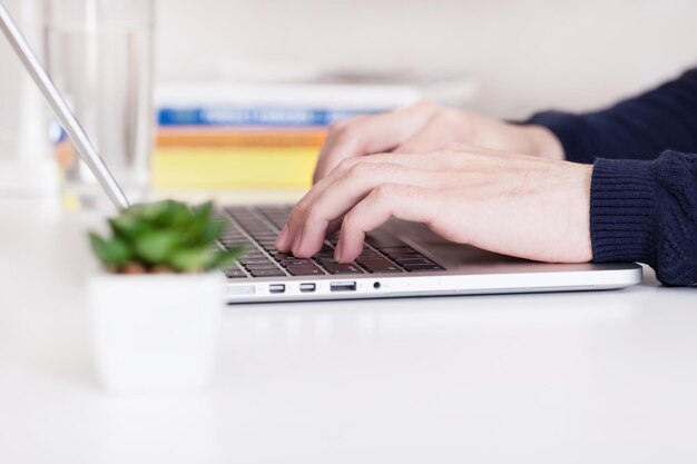 Man using a modern portable computer on an white table