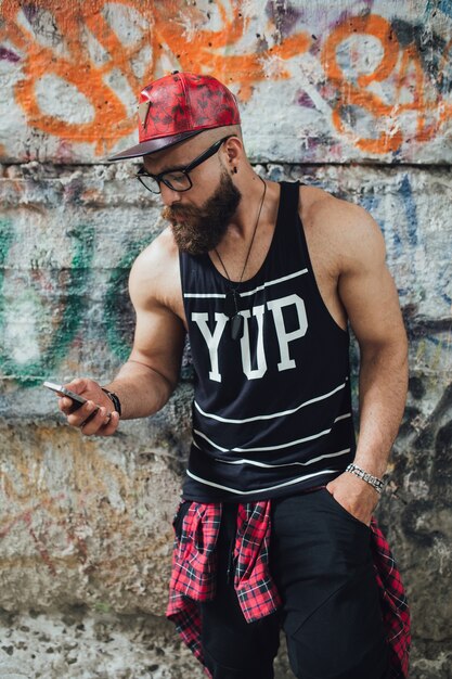 Man using phone near graffiti wall