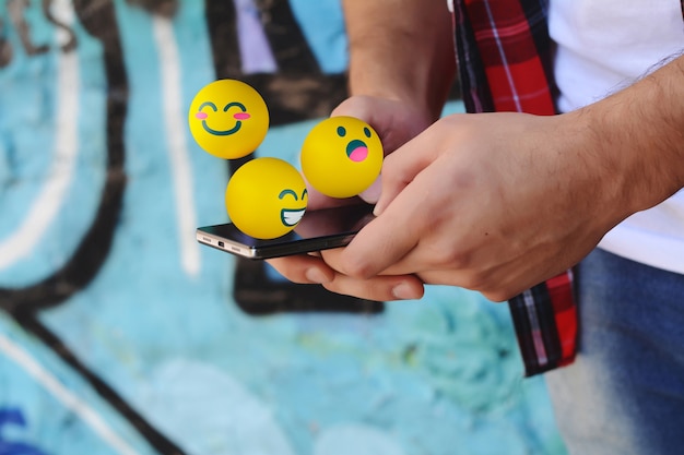 Photo man using phone sending emojis